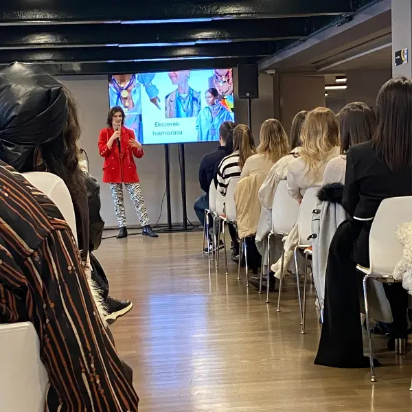Worshop előadás, stylist kivetítő előtt beszél a közönséghez